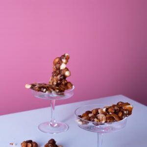 Peanut Brittle | Sugar free nut brittle with pink background in glass container | No lighting