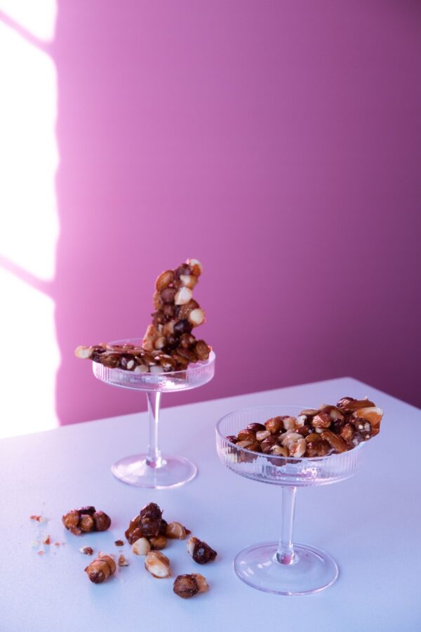 Peanut Brittle | Sugar free nut brittle with pink background in glass container