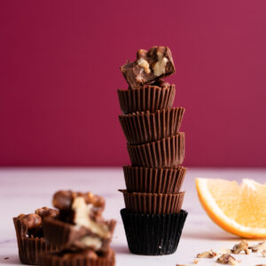 Sugar-free orange and walnut bites with dark pink background